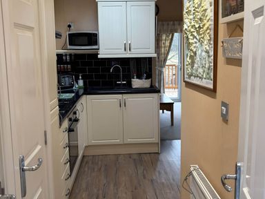 A kitchen with cabinets and appliances at 2 Bed Lodge-Sleeps 4-stunning views -Pet Friendly, Troutbeck