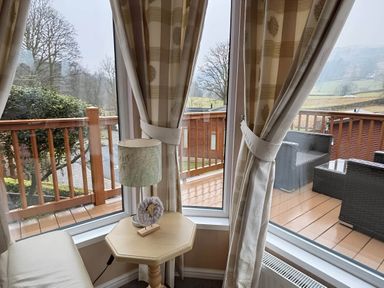 A living room with a side table and a lamp at 2 Bed Lodge-Sleeps 4-stunning views -Pet Friendly in Troutbeck