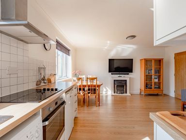 A kitchen with a dining area and television at Luxury 2 Bed Room Lake View Apt Bowness Parking Bowness-On-Windermere