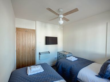 A bedroom with two beds and a television at Luxury 2 Bed Room Lake View Apt Bowness Parking Bowness-On-Windermere