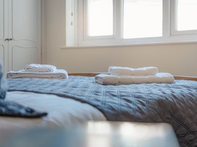 A bedroom with towels folded on the bed at Luxury 2 Bed Room Lake View Apt Bowness Parking Bowness-On-Windermere