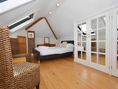 A bedroom with a bed and chairs at 4 Bed House-Sleeps 8-Parking-Pets-MarinaSeaView in Torquay
