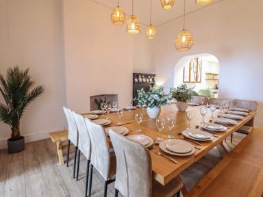 A dining room with a large table and chairs at Sea View, East Parade in Llandudno