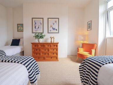 A bedroom with two beds and a dresser at Sea View, East Parade in Llandudno