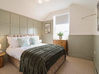 A bedroom with a bed and wooden furniture at Sea View, East Parade Llandudno