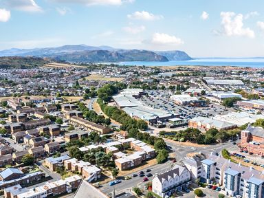 An aerial view of a town with houses, shops, and fields at Sea View, East Parade, Llandudno