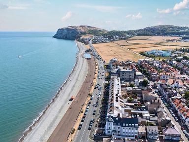 A coastline with beach and buildings at Sea View, East Parade Llandudno
