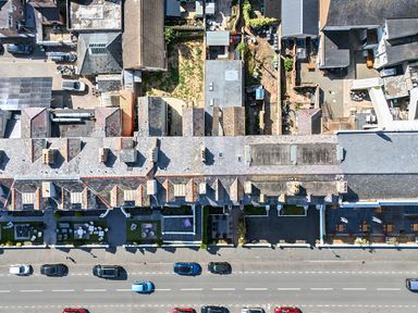 An outdoor area with rooftops, vehicles, and a garden at Sea View, East Parade in Llandudno