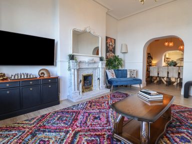 A living room with a fireplace and television at Sea View, East Parade in Llandudno