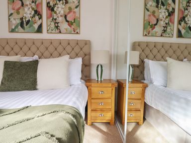 A bedroom with a bed and nightstands at Sea View, East Parade Llandudno