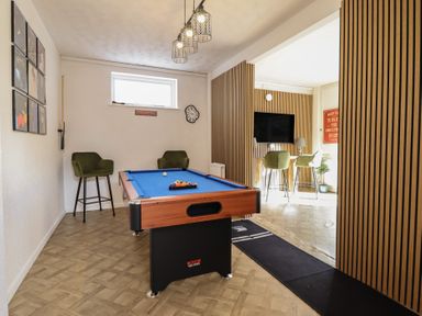 A game room with a pool table and bar stools at Sea View, East Parade Llandudno