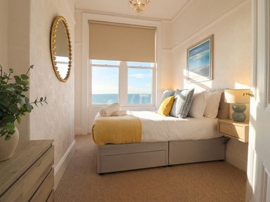 A bedroom with a bed and nightstand at Sea View, East Parade Llandudno