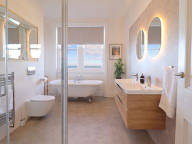 A bathroom with a bathtub and sink at Sea View, East Parade Llandudno