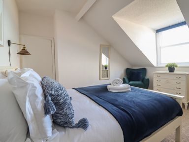A bedroom with a bed and chair at Sea View, East Parade in Llandudno