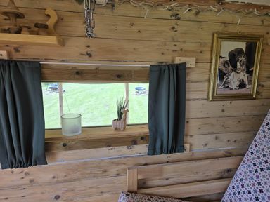 A living room with a window and curtains at Restored circus wagon in Saltburn-By-The-Sea