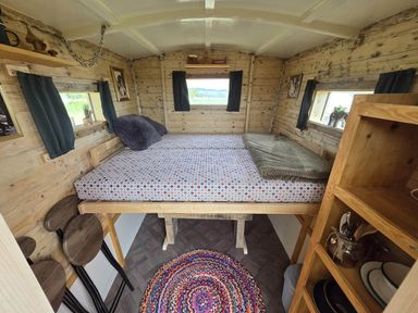 A bedroom with a bed and wooden decor at Restored circus wagon Saltburn-By-The-Sea