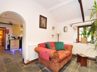 A living room with a sofa and lamp at Coach House, Camelford