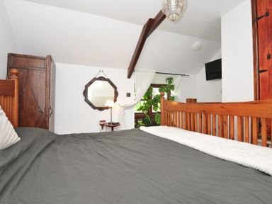 A bedroom with a bed and wardrobe at Coach House in Camelford
