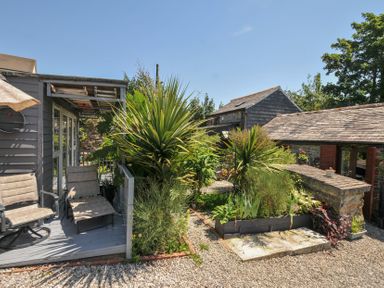 An outdoor area with a deck and plants at Coach House in Camelford