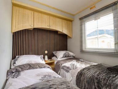 A bedroom with two beds and a window at Caravan at Argraig near Llanrhyddlad near Cemaes Bay
