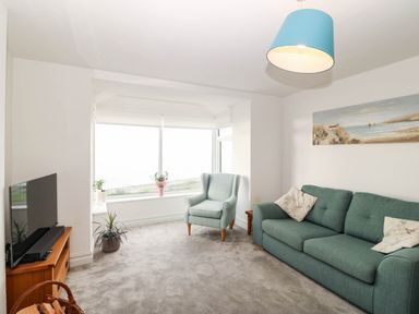 A living room with a television and sofa at Briar Bank in Barmouth