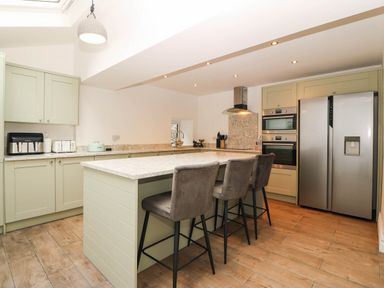 A kitchen with cabinets and appliances at Briar Bank in Barmouth