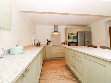 A kitchen with cabinets and appliances at Briar Bank in Barmouth