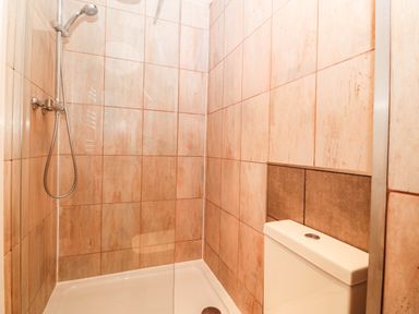 A bathroom with a shower and toilet at Briar Bank in Barmouth