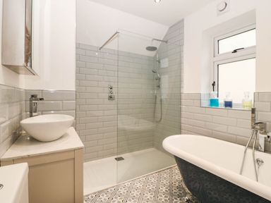 A bathroom with a shower, bathtub, sink, and toilet at Briar Bank in Barmouth