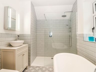 A bathroom with a bathtub and shower area at Briar Bank in Barmouth
