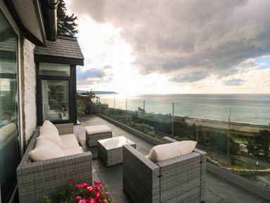 An outdoor seating area with couches and a view at Briar Bank in Barmouth