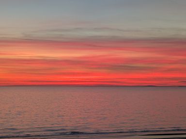 A scenic view of the sea and sunset at Briar Bank in Barmouth