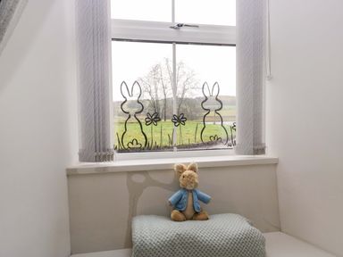 A bedroom with a stuffed toy on a blanket at Bobtail Cottage in Kendal
