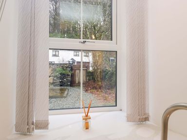 A bathroom with a window view at Bobtail Cottage in Kendal