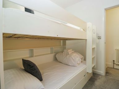 A bedroom with a bunk bed and shelves at Bobtail Cottage in Kendal