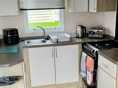 A kitchen with a sink and appliances at Static Caravan Hoburne Devon Bay in Paignton