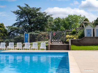 A swimming pool with poolside chairs at Static Caravan Hoburne Devon Bay in Paignton
