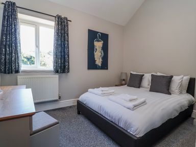 A bedroom with a bed and a desk at Elwy Cottage in St Asaph