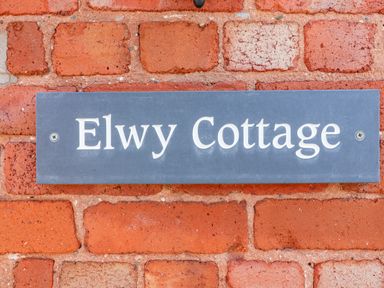 A nameplate on a brick wall at Elwy Cottage in St Asaph