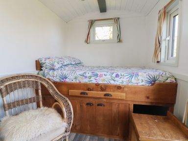 A bedroom with a bed and a chair at Shepherds Delight in Biddulph Moor
