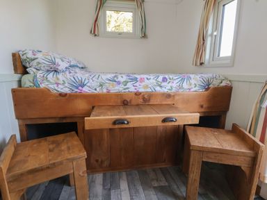 A bedroom with a wooden bed and table at Shepherds Delight in Biddulph Moor
