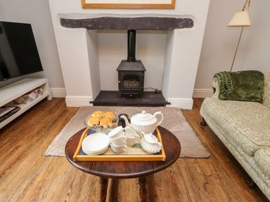 A living room with a fireplace and tea set at 3 Tre Felin Llandygai near Bangor