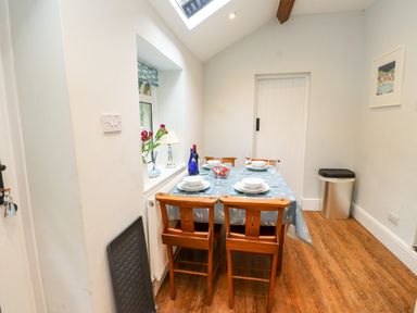 A dining room with a table set for meals at 3 Tre Felin in Llandygai near Bangor