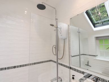 A bathroom with a shower and mirrors at 3 Tre Felin in Llandygai near Bangor