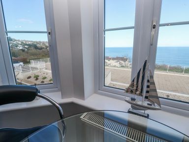 A sitting room with a boat decoration and a view of the ocean at 21 Compass Point in Carbis Bay