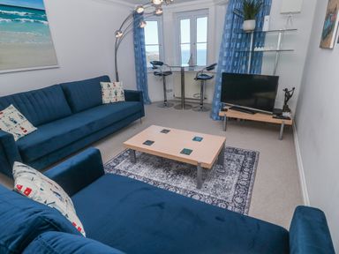 A living room with a sofa, coffee table, and television at 21 Compass Point, Carbis Bay
