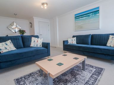 A living room with sofas and a coffee table at 21 Compass Point in Carbis Bay