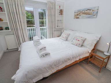 A bedroom with a double bed and shelves at 21 Compass Point, Carbis Bay