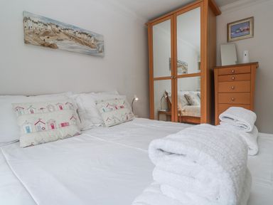 A bedroom with a bed and wardrobe at 21 Compass Point, Carbis Bay