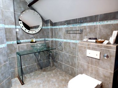 A bathroom with a sink, toilet, and mirror at Kaber Chapel near Kirby Stephen